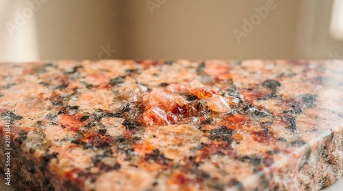 Close-up of a polished granite surface with visible mineral crystals and a wet, reflective finish.