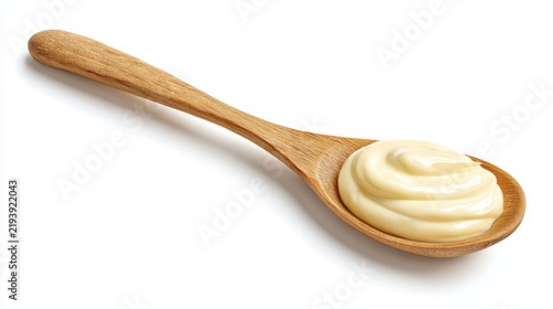 Creamy mayonnaise swirl on wooden spoon isolated on white background