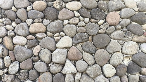 Foto Natural round pebble stone pattern captured in close up, revealing smooth surfaces, varied shapes, earthy colors, and tactile texture, ideal for landscaping, flooring, architecture, and decor