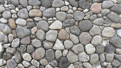 Obraz na plátne Detailed close up of round pebble stone texture showing smooth surfaces, natural shapes, earthy tones, and organic patterns, ideal for landscaping, construction, interior design, and decor