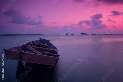 Cuadro en lienzo Serene tropical seascape featuring a traditional wooden fishing boat resting in