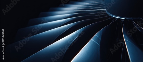 Close-up of turbine blades, curved and metallic with blue lighting against a dark background