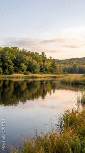 Serene autumn landscape featuring a calm river reflecting colorful trees at sunset in the wilderness