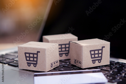 Shopping online. Credit card and cardboard box with a shopping cart logo on laptop keyboard. Shopping service on The online web. offers home delivery