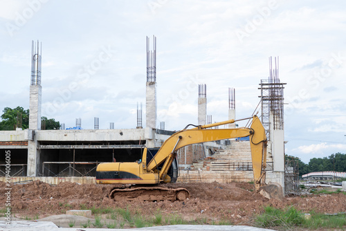 Cuadro en lienzo Yellow excavator machinery works on dirt ground at active building construction