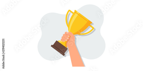 Winner trophy held in human hand featuring gold cup for competition victory or success achievement.