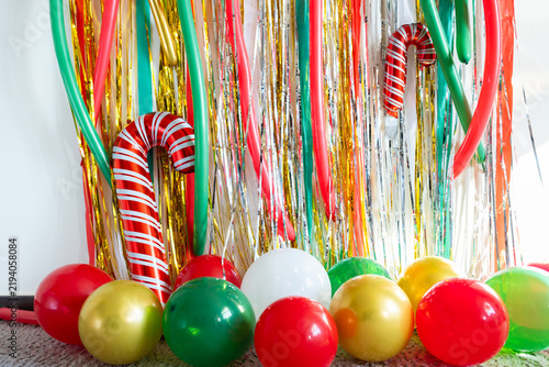 Colorful holiday decorations with balloons and candy cane inflatables indoors