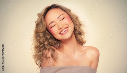 Beautiful Asian Woman Smiling with Closed Eyes, Happy Young Female Beauty Portrait with Wavy Hair, Glowing Skin and Makeup for Cosmetics Concept. generative AI