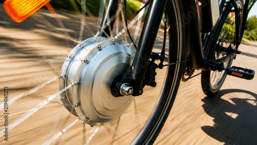 Close Up Shot of Electric Bicycle Hub Motor on Front Wheel Moving with Motion Blur for Sustainable Urban Transportation Concept