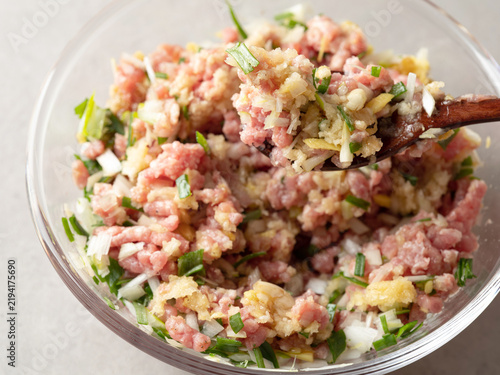 Minced meat, vegetables, and dumpling filling in a bowl.