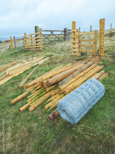 фотографія Newly installed fences and gates and a stack of agricultural fencing supplies fo
