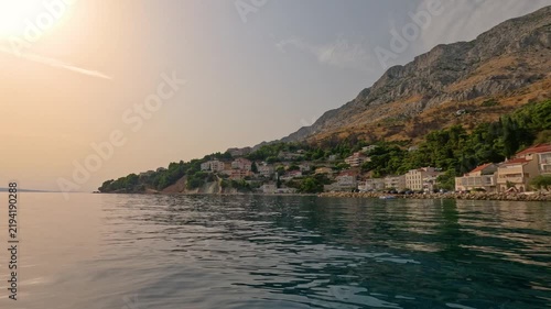 Calm Adriatic coastline with mountain town at sunset in Croatia