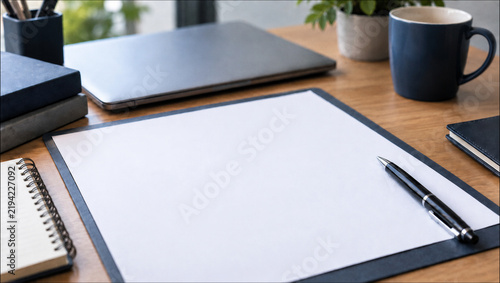 Modern office desk with blank paper, pen, laptop and coffee mug with copy space