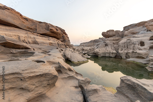 Deep eroded rock canyon with calm green water reflection at Sam Phan Bok in Ubon Ratchathani.