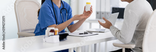 Obraz na plátne doctor explain drug bottle instructions with a patient in a hospital office