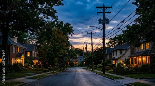 Suburban Street at Dusk with Glowing Houses and Power Lines