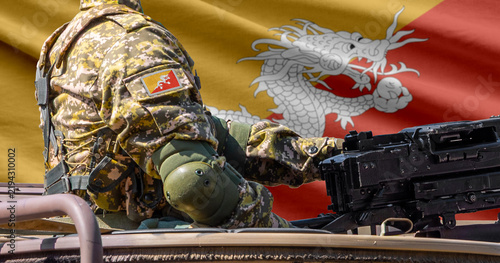 Obraz na plátne Bhutan flag with soldier at machine gun turret in front of it