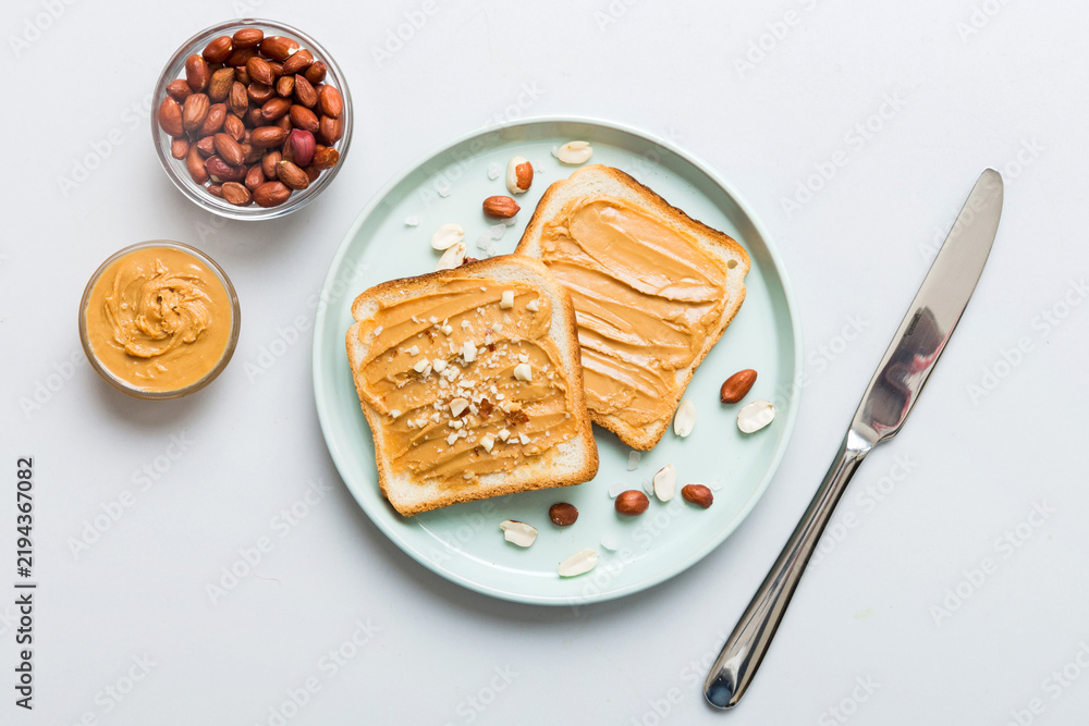 Obraz premium Peanut butter sandwiches or toasts on light table background.Breakfast. Vegetarian food. American cuisine top view vith copy space