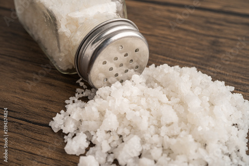 Obraz na płótnie Sodium chloride sea salt with salt shaker.