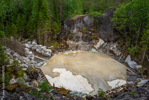 Konstfotografi Natural hot spring with steam rising in a forested, rocky landscape