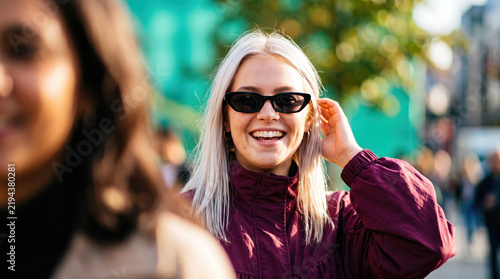 Young woman smiling in black sunglasses for stylish outdoor fashion and modern eyewear concept