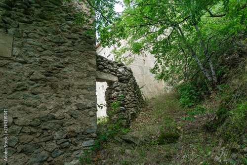 The weathered wall of a medieval building made of stones of different shapes and sizes, bonded with lime, with a passage near the tower. Amlivi, Amlevi complex. Kvemo Kartli, Tetritskaro, Georgia