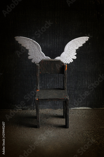 Empty black chair with angel wings