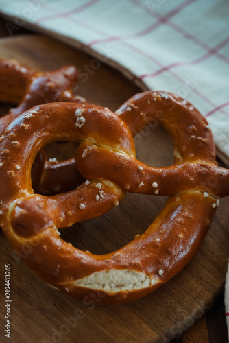 Freshly Baked Salted Soft Pretzels - bavarian lye brown pastry - on Wooden Board