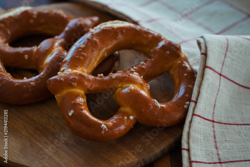 Freshly Baked Salted Soft Pretzels - bavarian lye brown pastry - on Wooden Board