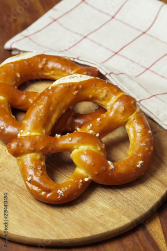 Freshly Baked Salted Soft Pretzels - bavarian lye brown pastry - on Wooden Board