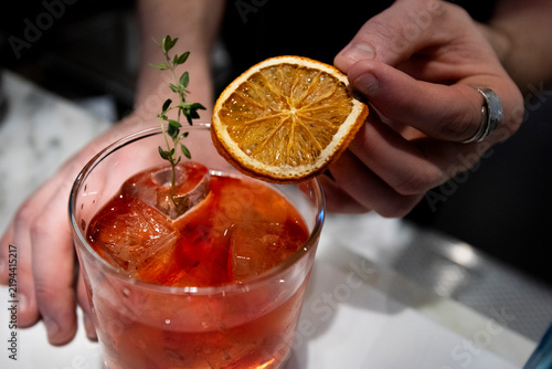Fotografie Crafting a Refreshing Cocktail With Dried Citrus and Thyme at a Trendy Bar