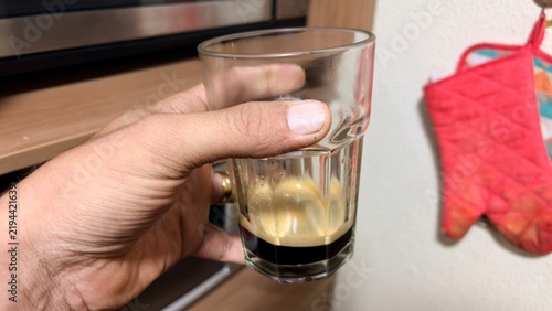Картината върху платно Hand holding invigorating espresso coffee shot in glass