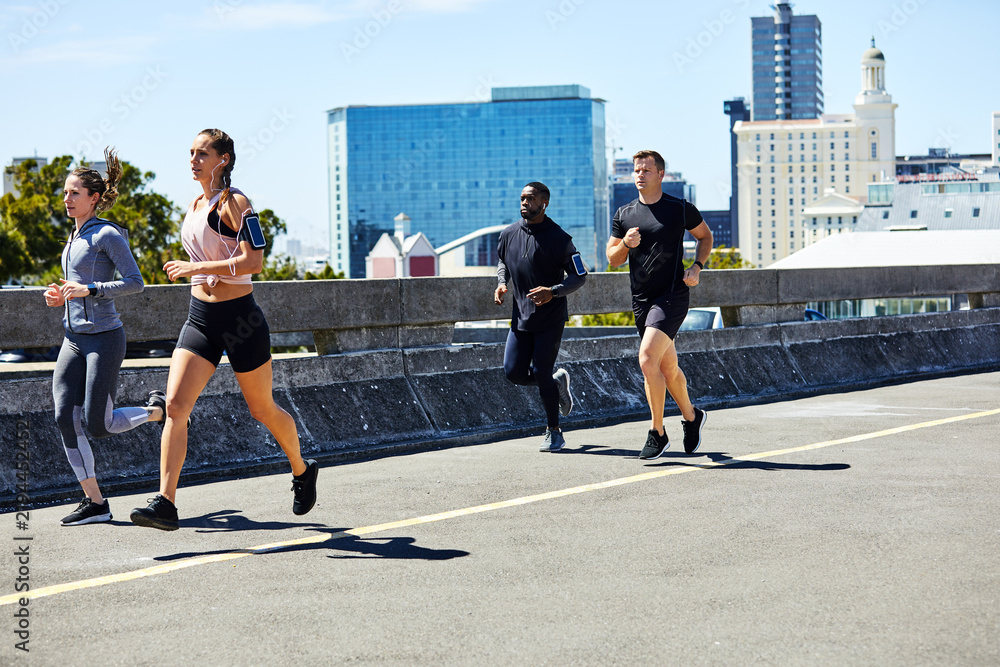 Fototapeta premium Running, people and fitness in city with cardio, wellness and endurance training for marathon. Runner, group or club with exercise for race preparation, sports activity and health in urban town