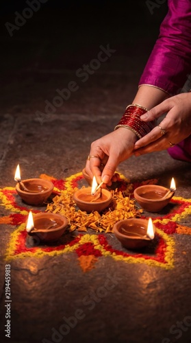 Hand lighting diya oil lamps for Diwali celebration