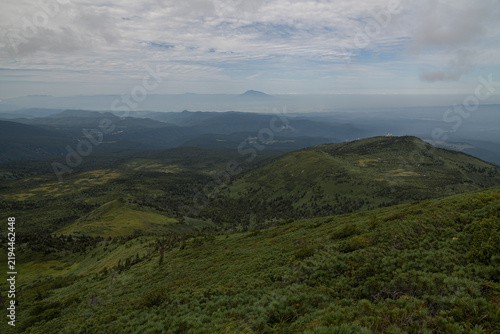 Green summer mountains of Hakkoda with Mount Iwaki fading into haze