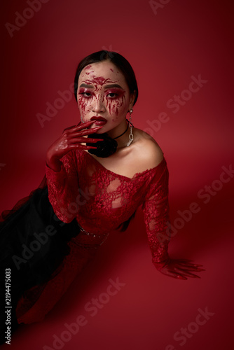 Dark queen with a bloody face posing hauntingly for Halloween celebration