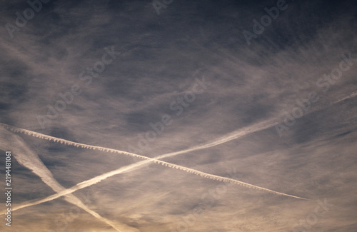 jet trails on cloudy sky at dusk