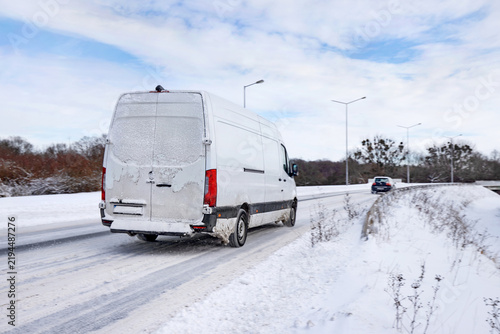 Weißer Transporter auf einer Straße mit Schnee im Winter