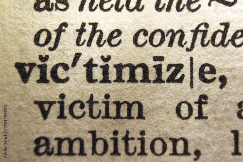 Bild auf Leinwand Word victimize printed on dictionary page, macro close