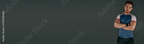 Konstfotografi Sporty young man poses confidently in athletic attire against a dark backdrop