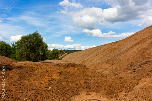 Foto Heavy machinery excavating ground for highway expansion project with large dirt