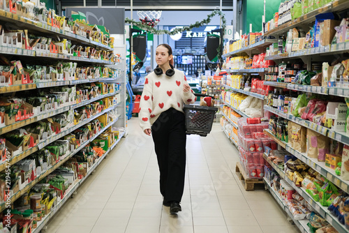 Obraz na płótnie Independent teenage girl shopping alone in supermarket represents self reliance