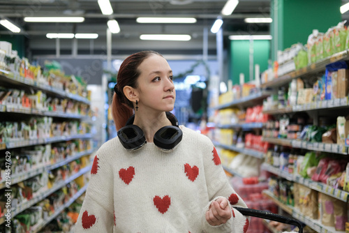 Foto Thoughtful teenage shopper in supermarket represents consumer autonomy personal