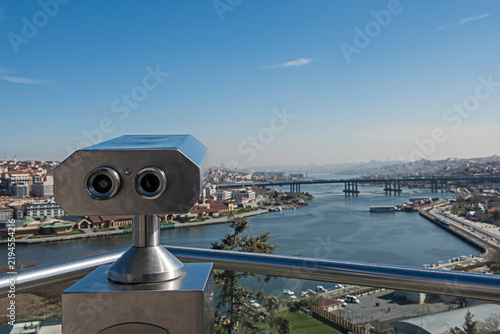 Closeup detail of binoculars on a viewing platform overlooking large Bosphorus river and Istanbul Turkey from famous Pierre Loti Cafe panorama landscape