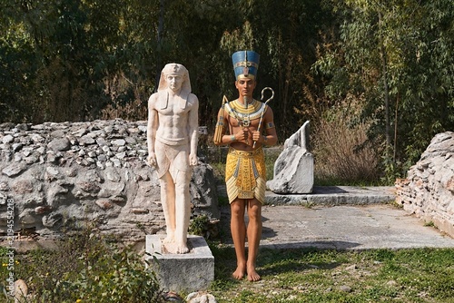 The ancient Egyptian god Osiris next to a modern copy of his statue at the sanctuary of the Egyptian Gods in Marathon, Greece