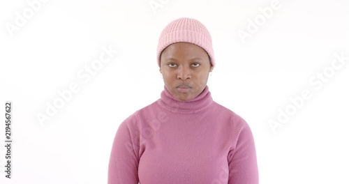 Person in pink sweater and beanie meditating with eyes closed, finding inner peace