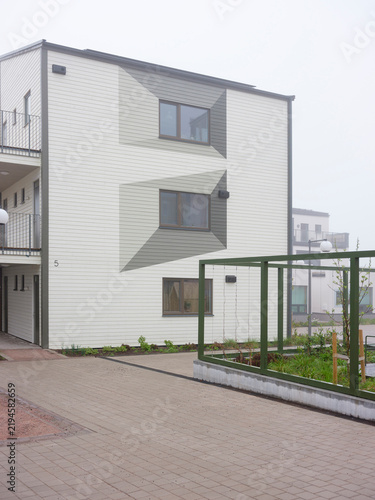 Obraz na plátně Apartment building next to sidewalk with fence