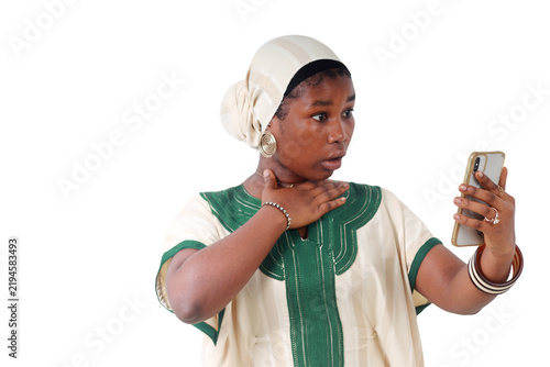 African woman surprised, looking at her phone, hand on her throat
