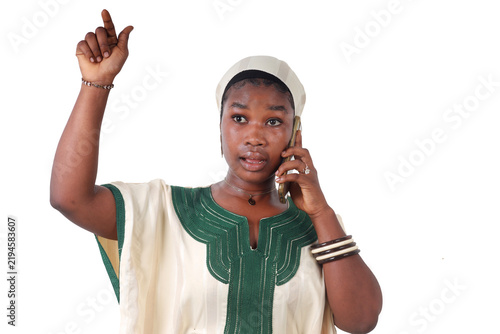 African woman on the phone, arm raised in celebration