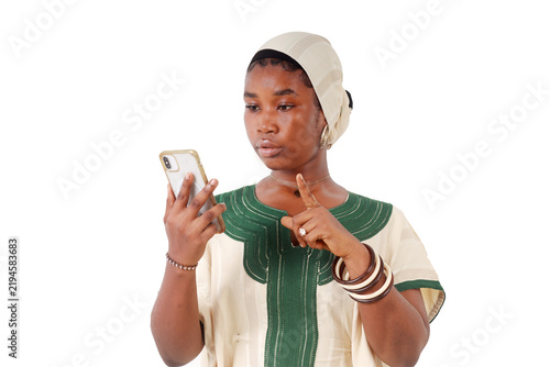 Serious African woman dictating a message while looking at her phone
